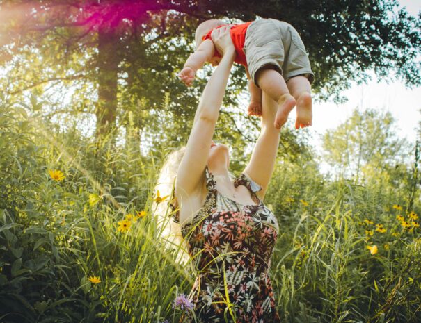 Mom lovingly holding baby above her in the air